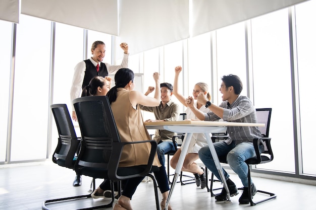 Equipe bem-sucedida de empresários fazendo gestos felizes na sala de conferências. Conceito de sucesso do trabalho em equipe.