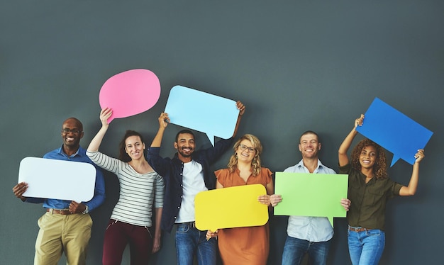 Equipe casual sorridente de diversas pessoas segurando bolhas do discurso de opinião para expressar sua importante mensagem de comunicação Grupo criativo em pé com placas de sinal de copyspace coloridas juntas em uma fileira