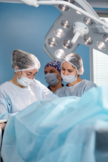 Equipe cirúrgica concentrada operando um paciente em uma sala de operação