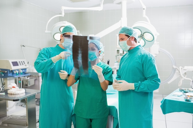 Equipe cirúrgica falando sobre um raio-X