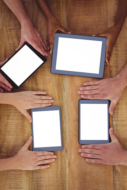 Equipe criativa trabalhando em conjunto em um tablet e smartphones