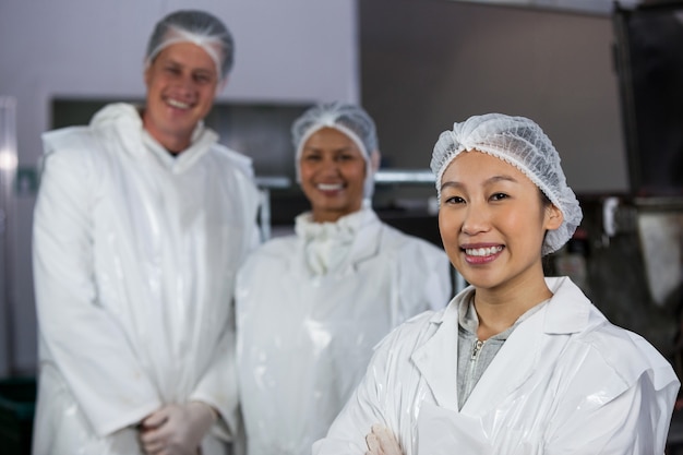 Equipe de açougueiro em pé na fábrica de carne