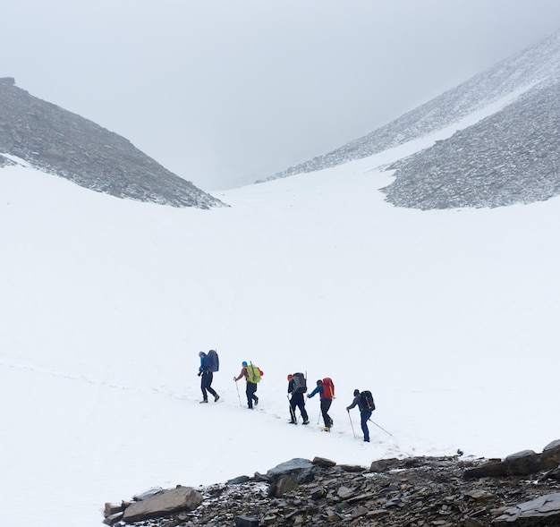 Equipe de alpinistas andando no caminho nevado