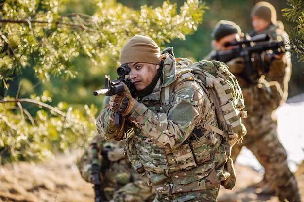 Equipe de armas de forças especiais na floresta fria Guerra de inverno e conceito militar