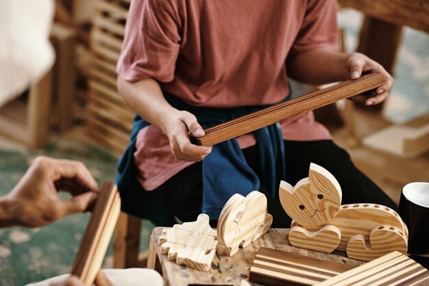 Equipe de carpinteiros fazendo tábuas de corte de grãos de ponta e brinquedos de madeira de alta qualidade na oficina