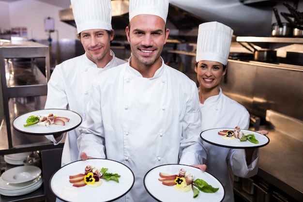 Equipe de chefs apresentando seus pratos