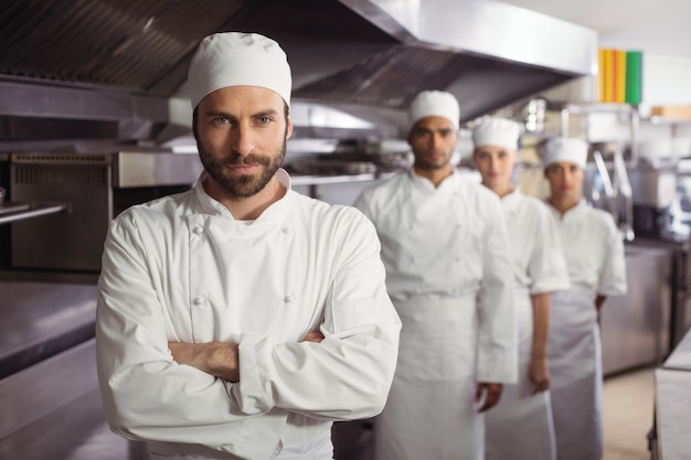 Equipe de chefs felizes juntos em uma cozinha comercial