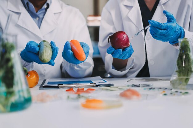 Equipe de cientistas asiáticos em um laboratório conduzindo pesquisa de alimentos usando um microscópio e equipamentos de laboratório mostrando inovação em ciência de alimentos e biotecnologia