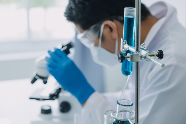 Foto equipe de cientistas de pesquisa bioquímica trabalhando com microscópio para desenvolvimento de vacina contra coronavírus em foco seletivo de laboratório de pesquisa farmacêutica