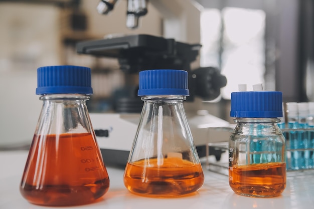 Foto equipe de cientistas de pesquisa bioquímica trabalhando com microscópio para o desenvolvimento de vacina contra o coronavírus em laboratório de pesquisa farmacêutica foco seletivo