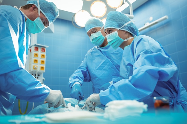 Equipe de cirurgiões realizando operação no teatro de operação
