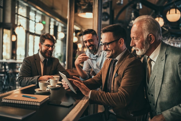 Equipe de colegas trabalhando no pub e usando tecnologia