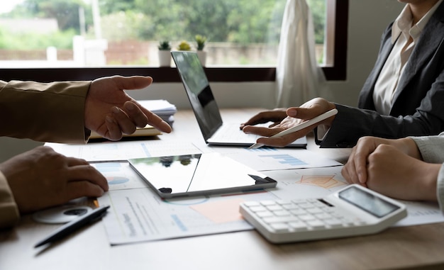 Equipe de contabilidade de negócios que faz brainstorming de dados financeiros em calculadora de laptop e papelada