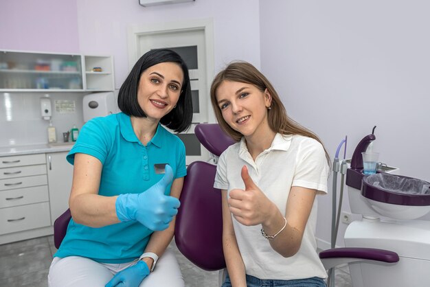 Foto equipe de dentistas e paciente feliz mostrando polegares para cima conceito de dentistas felizes