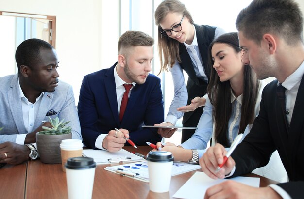 Equipe de empresários discutindo à mesa no escritório criativo