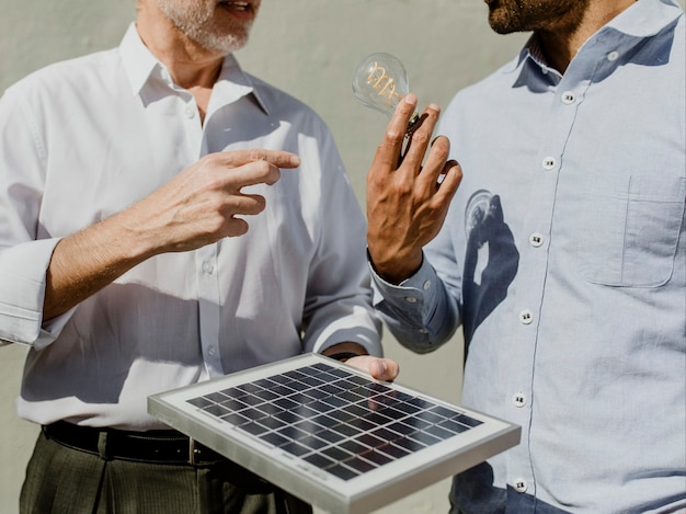 Foto equipe de engenharia ecologicamente correta com painel solar