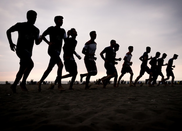 Equipe de formação de jovens na praia do sol