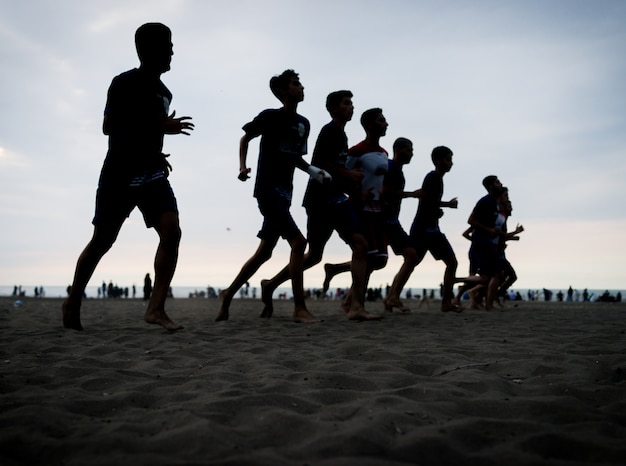 Equipe de formação de jovens na praia do sol