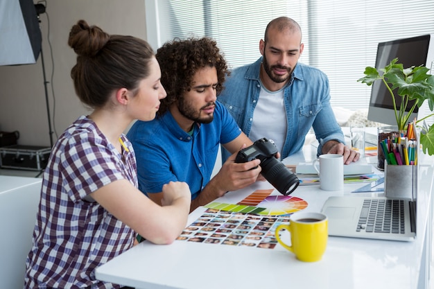 Equipe de fotógrafos trabalhando juntos na mesa