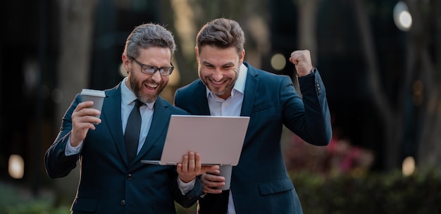 Foto equipe de homens de duas equipes de negócios usando tablet laptop equipe de homens de negócios ao ar livre usando laptop de negócios ao ar livre