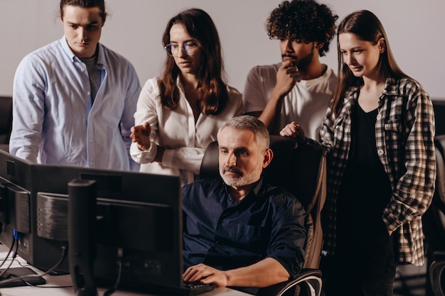 Equipe de inicialização durante o brainstorming Colegas discutindo tarefas difíceis Colegas de trabalho em pé perto do computador no escritório