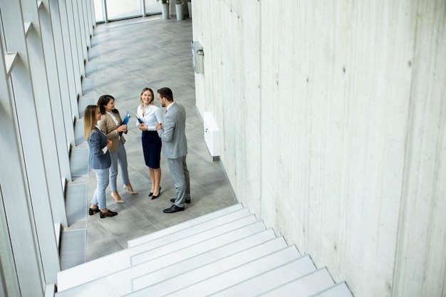 Equipe de inicialização jovem tem uma discussão por escadas no corredor do escritório