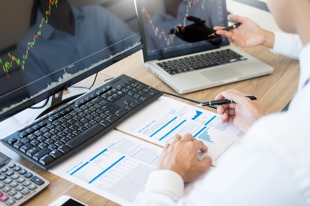 Foto equipe de investimento empreendedor discutindo e analisando gráficos de negociação e gráficos no computador