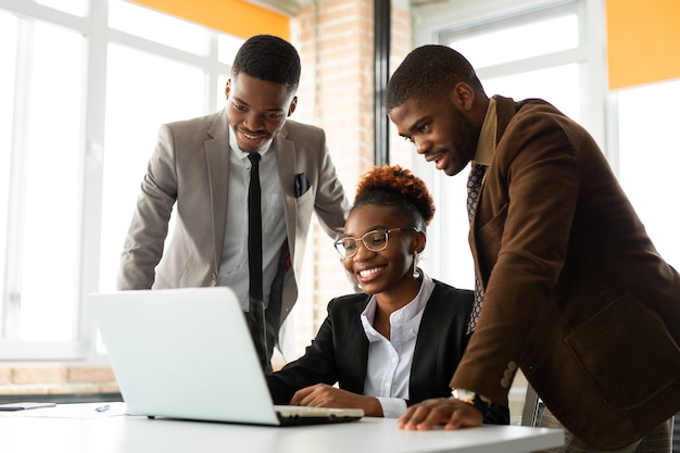 equipe de jovens africanos no escritório à mesa com laptop