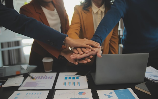 Foto equipe de jovens empresários asiáticos e startups têm reunião de negócios e encorajam-se mutuamente para o bom espírito energia para realizar o conceito de plano de marketing bem sucedido