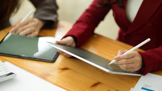 Equipe de marketing fazendo planos de marketing em um tablet digital moderno juntos e passando um tempo no escritório