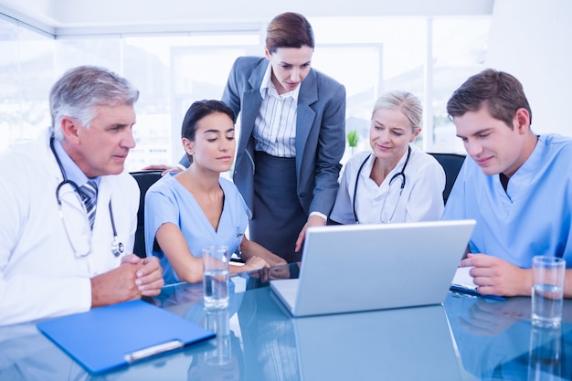 Equipe de médicos e empresária tendo uma reunião no consultório médico