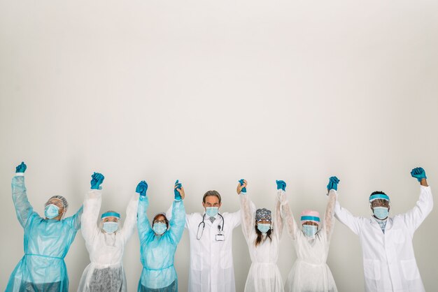 Foto equipe de médicos e enfermeiras vestindo roupas de proteção descartáveis e máscaras faciais para lutar contra covid19