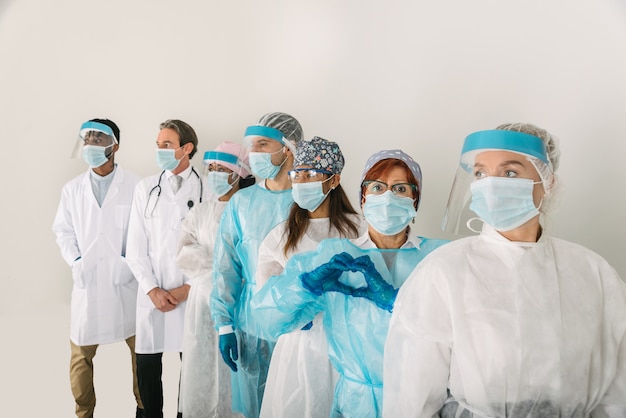 Equipe de médicos e enfermeiras vestindo roupas de proteção descartáveis e máscaras faciais para lutar contra covid19
