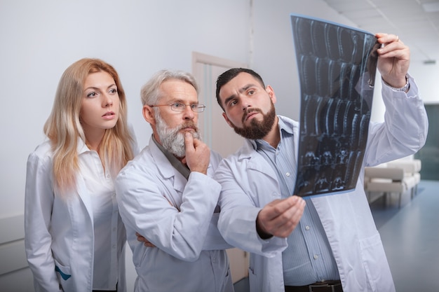 Equipe de médicos examinando ressonância magnética juntos