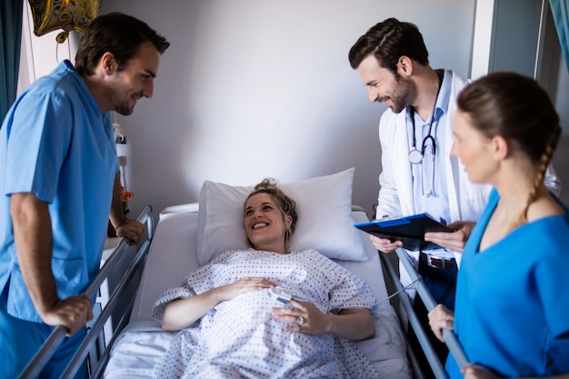 Equipe de médicos interagindo com a mulher grávida