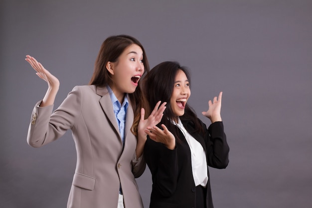 Equipe de mulheres de negócios feliz, alegre, animada e surpresa, olhando para cima