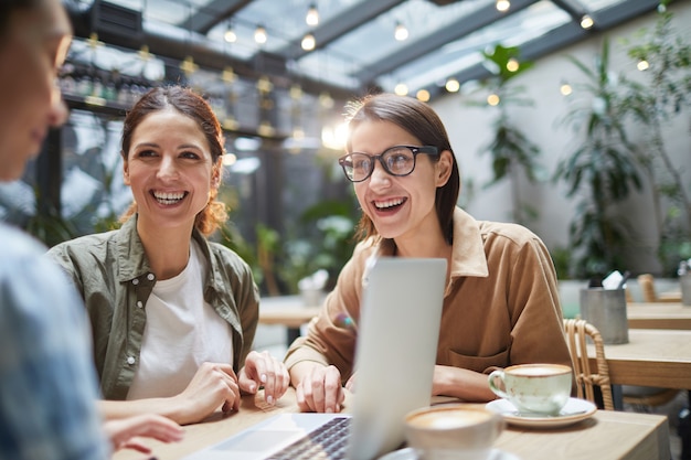 Equipe de negócios alegre trabalhando no café ao ar livre