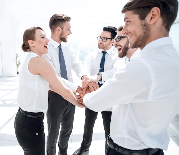 Foto equipe de negócios amigável em pé no escritório o conceito de trabalho em equipe