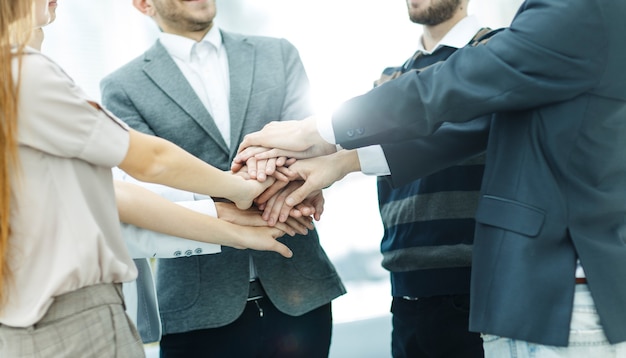 equipe de negócios amigável formando um círculo e juntando as mãos