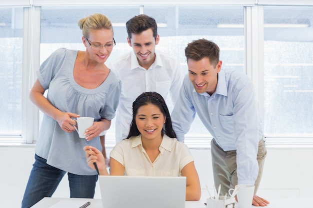 Equipe de negócios casual olhando laptop juntos