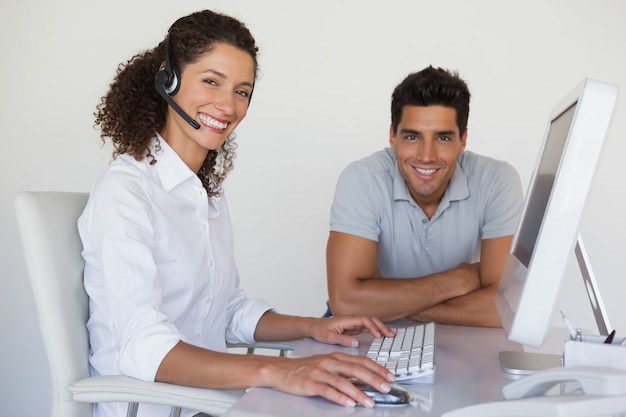 Equipe de negócios casual sorrindo para a câmera juntos na mesa