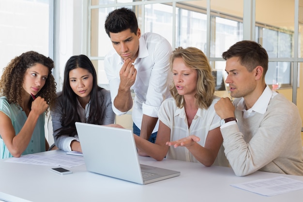 Equipe de negócios casual tendo uma reunião usando laptop