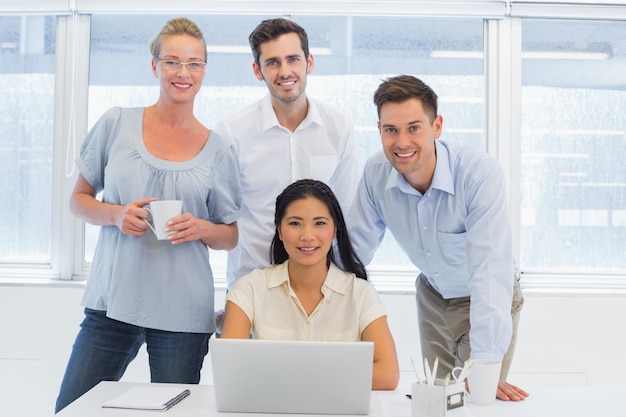 Equipe de negócios casual usando laptop juntos na mesa