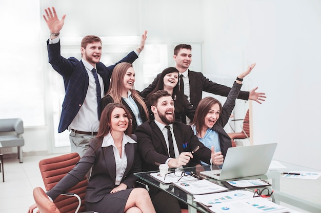 equipe de negócios com as mãos para cima e votando para a tomada de decisões perto do desktop