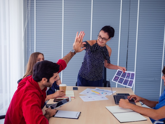 Equipe de negócios comemorando a vitória no escritório, sucesso nos negócios