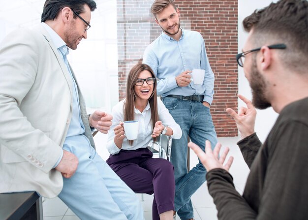 Equipe de negócios conversando e sorrindo durante a pausa para o café no escritório