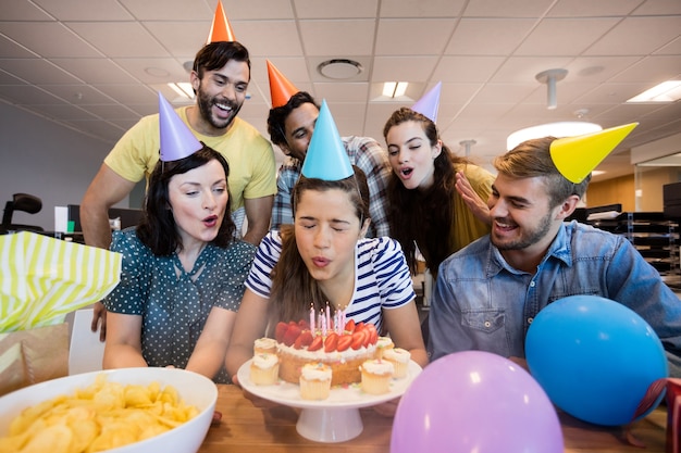 Equipe de negócios criativos comemorando aniversário de colegas no escritório