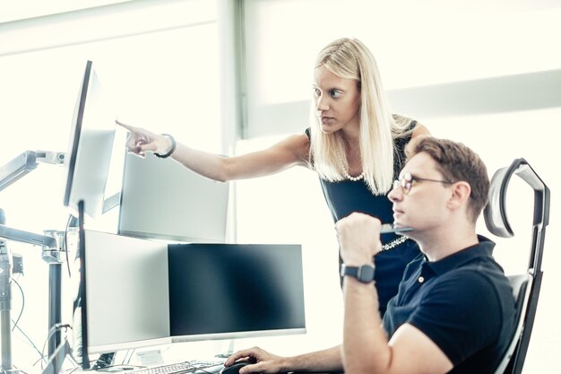 Equipe de negócios de corretores de ações negociando on-line assistindo gráficos e análises de dados em vários computadores