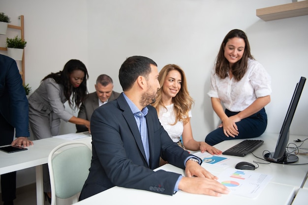 Foto equipe de negócios de homens e mulheres em um escritório analisando a evolução da empresa