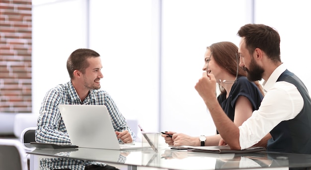 equipe de negócios discutindo algo sentado à mesa do escritório. o conceito de uma startup